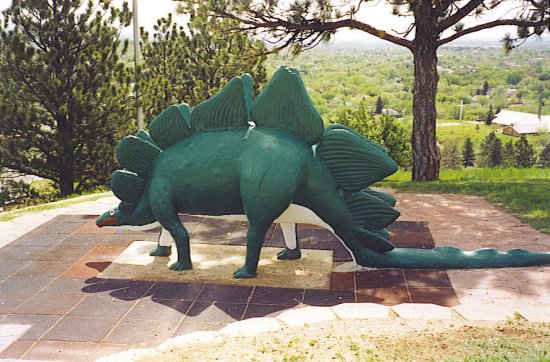 This picture shows a Stegosaurus model found at a dinosaur park. Stegosaurus were herbivores and featured rows of unique bones along their back and tail.
