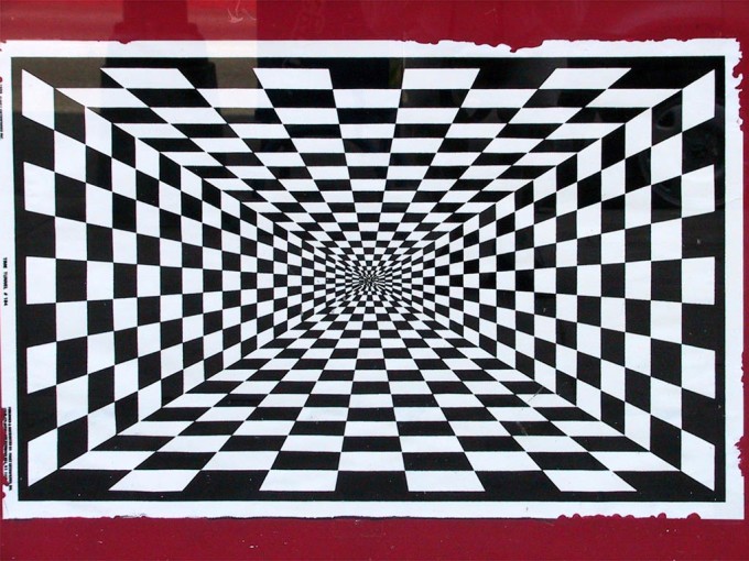 This image gives the illusion of depth. As one looks at the picture the black and white squares appear to form walls which lead down a long corridor.