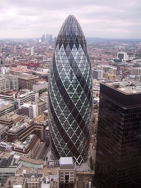 This is a photo of 30 St Mary Axe, which is also known as the Swiss Re Building or simply the Gherkin. This unique skyscraper is found in the main financial district of London, England. Standing 180 metres (591 ft) tall, the Gherkin opened in May 2004.