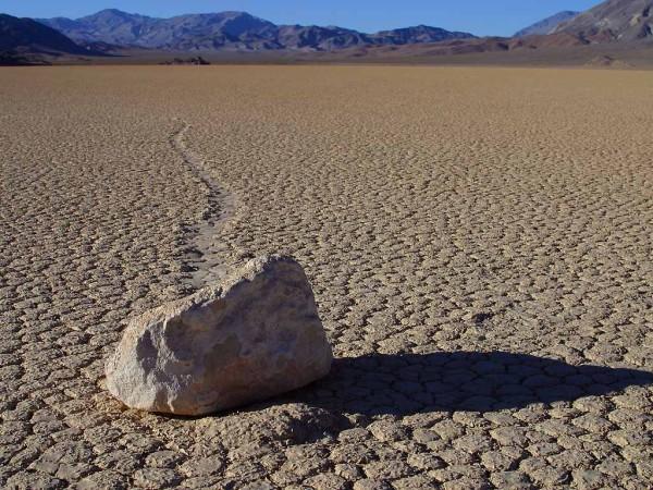 A single rock breaks up the desolate monotony of a desert landscape. The heat dries up any liquid that emerges from the ground or skies before it has a chance to help create visible life forms.