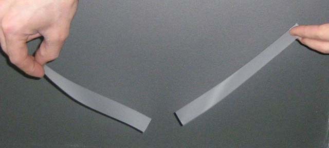 This image demonstrates the force of attraction between oppositely charged objects, in this case two pieces of tape.