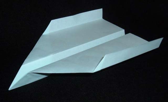 This image shows a well designed paper plane with clean folds set against a black background.