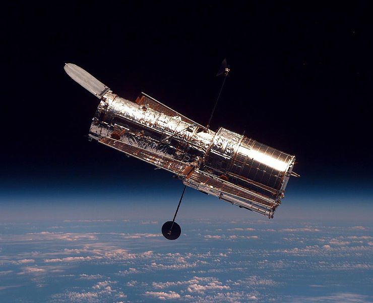 A clear photo of the famous Hubble Space Telescope with Earth and space in the background.