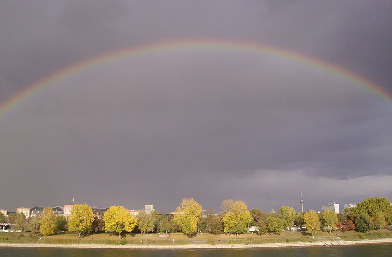 A beautiful rainbow stretches across the sky after a rain shower on a cloudy day in Mannheim, Germany.