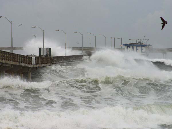 The photo shows some of the extreme weather effects cause by the El Nino weather pattern. Huge water swells and waves crash into a seaside pier.
