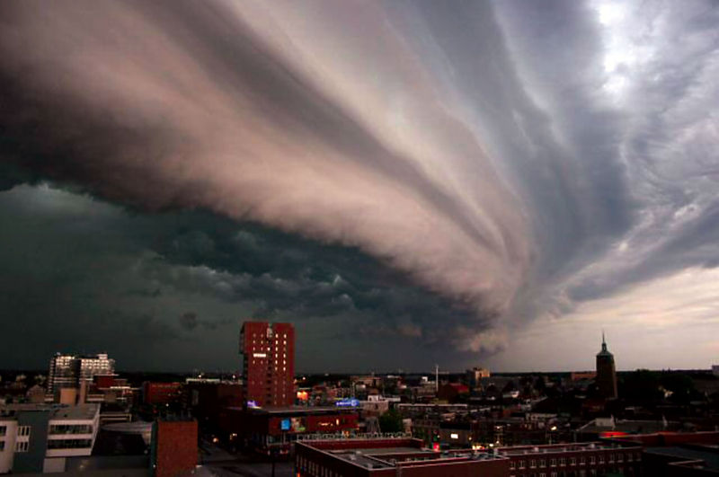 This unbelievable photo shows an imposing rolling thunder cloud making its way over a city in the Netherlands. It dumps large amounts of water in the process and unleashes spectacular displays of thunder and lightning.