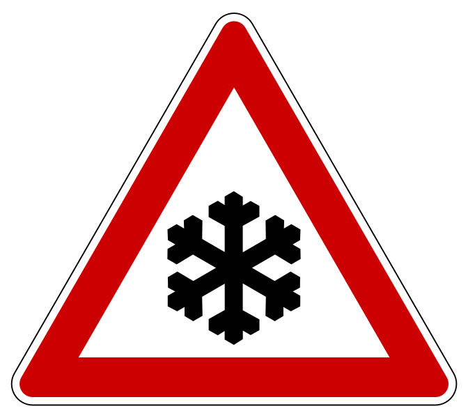 This snow warning sign is used to alert people of possible snow dangers in the area. This risk can be particularly dangerous for those traveling in vehicles. The sign features a black snowflake inside a red triangle.